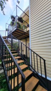 Деревянная лестница на двух металлических косоурах в коттедже